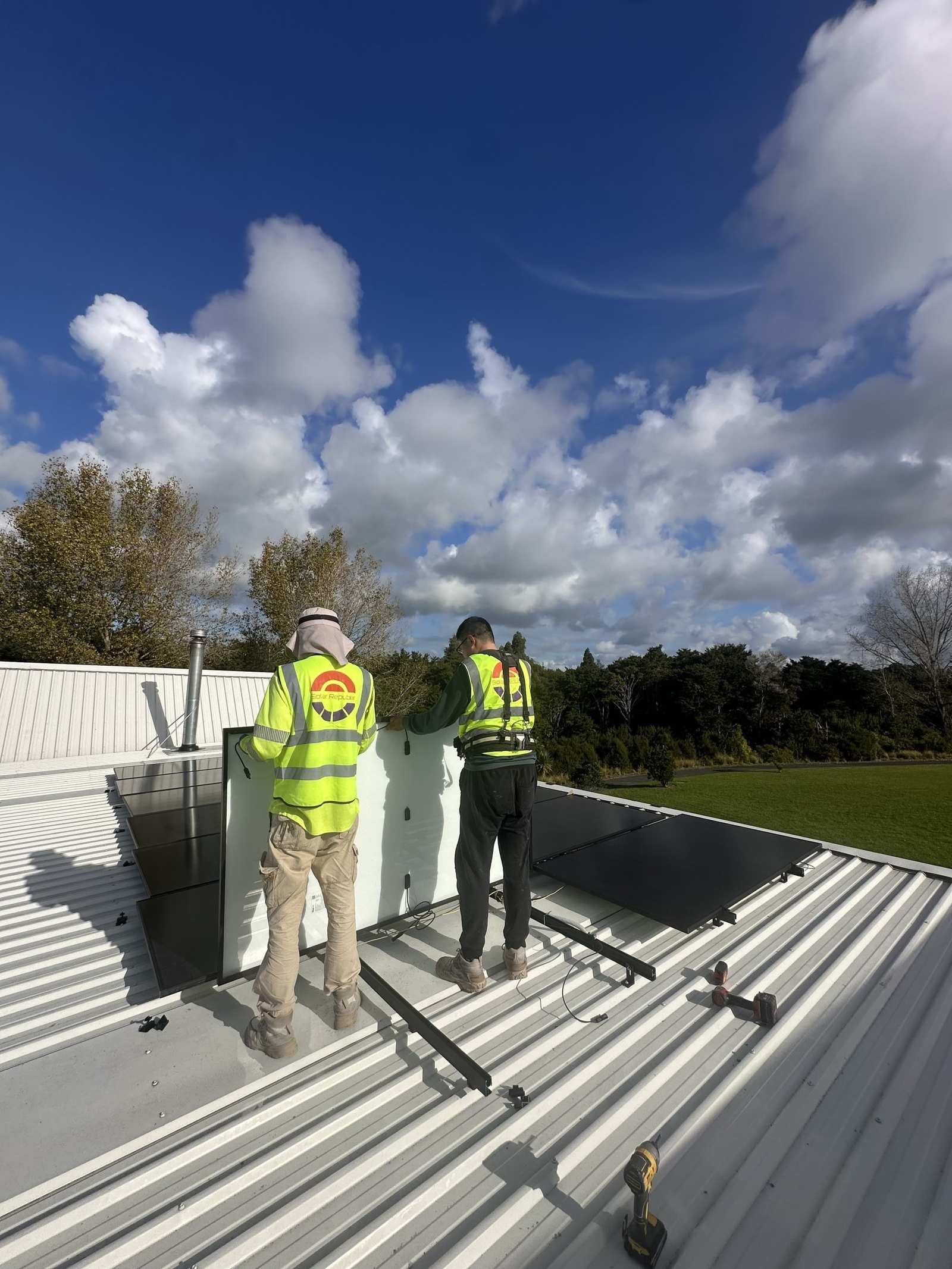 Installers fitting panels on the Colorsteel roof