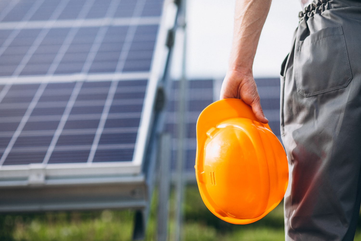 Man worker in the field by the solar panels